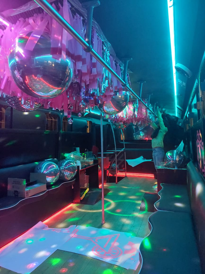 Siluetas bailando en la unidad Black bajo luces neón moradas y rosas