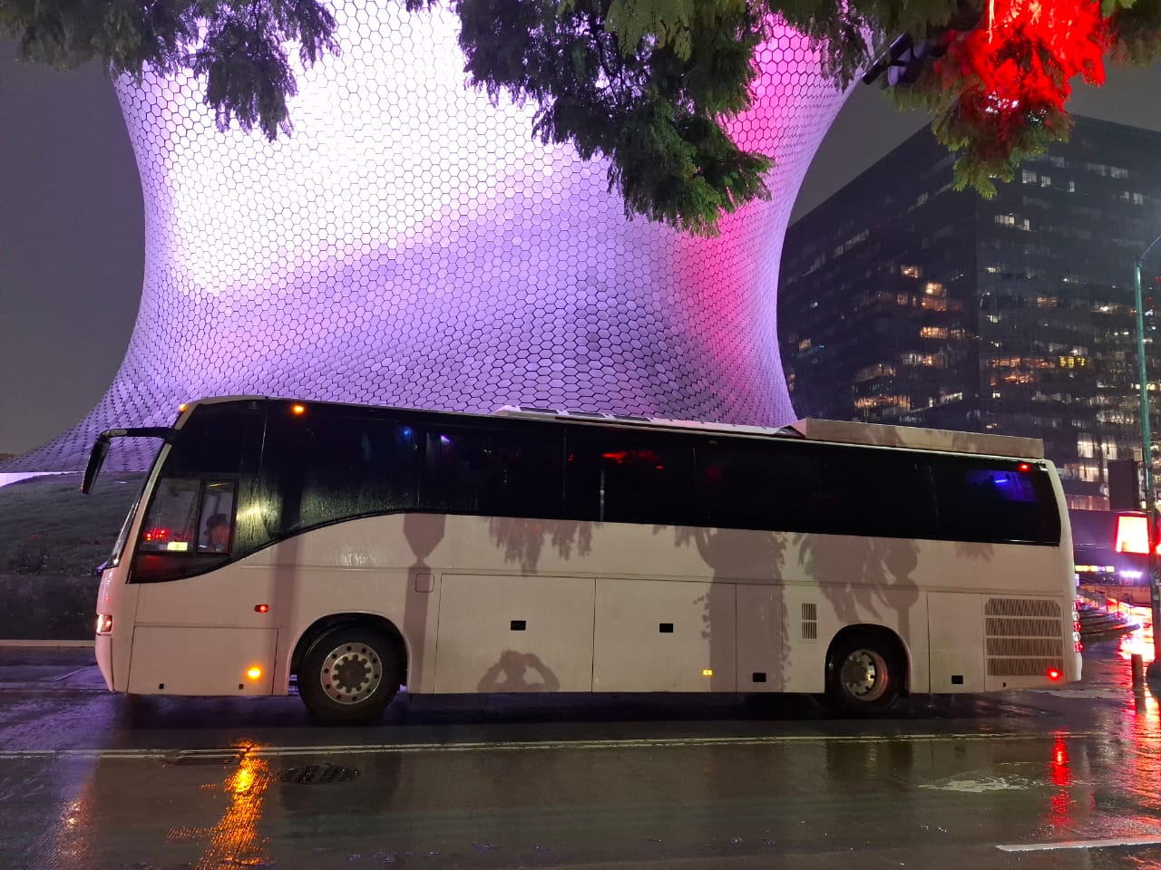 Party bus Golden iluminado con luces cálidas doradas en la ciudad de noche